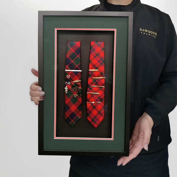 A collection of Dad's multiple tie pins creatively displayed on two ties and framed in matching Scottish tartan colours.