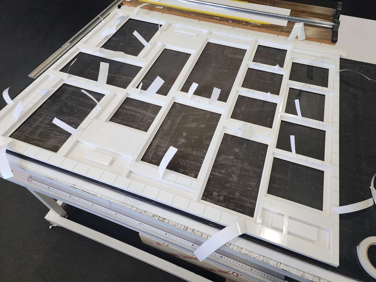 The process of layering and bracing the back of the artwork: A complex collection of multiple autographed Jay Zhou CDs and DVD's framed