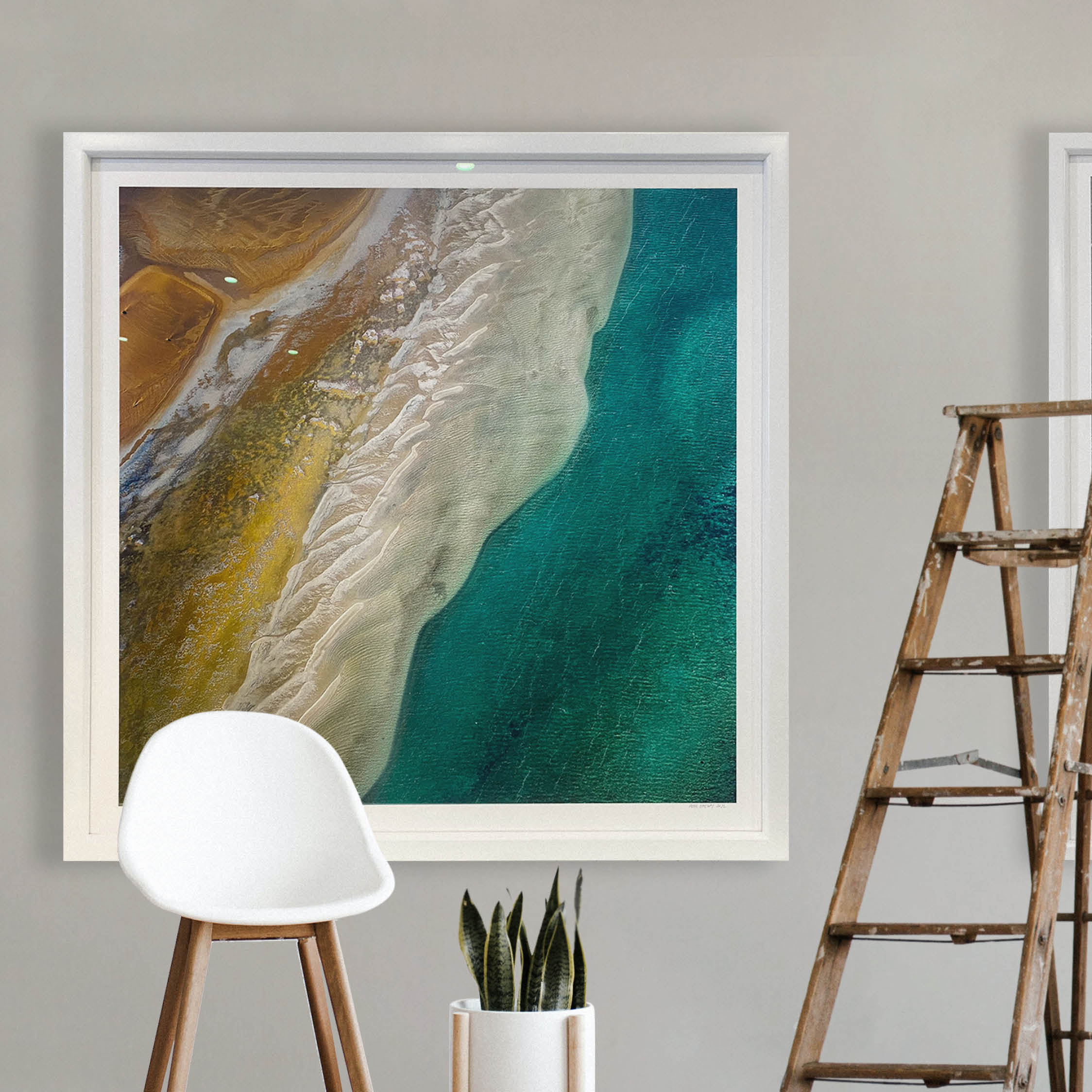 Stunning coastal print framed in white of an arial beach and ocean scene.