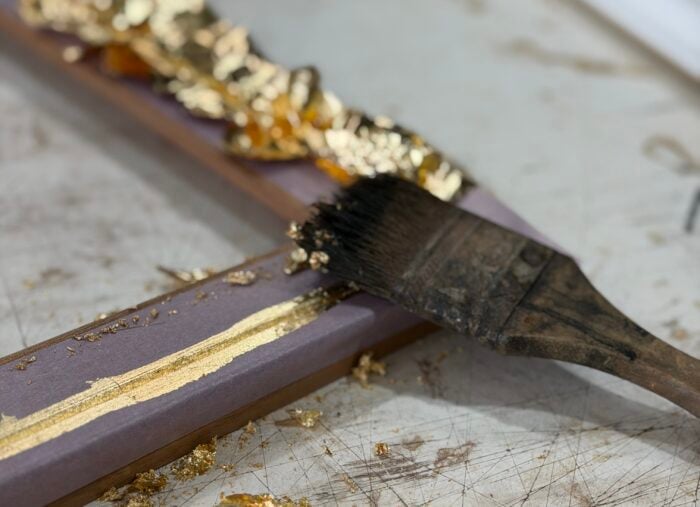 A close up of a hand gilded frame with brush mid process at Dawsons Framing Gold Coast