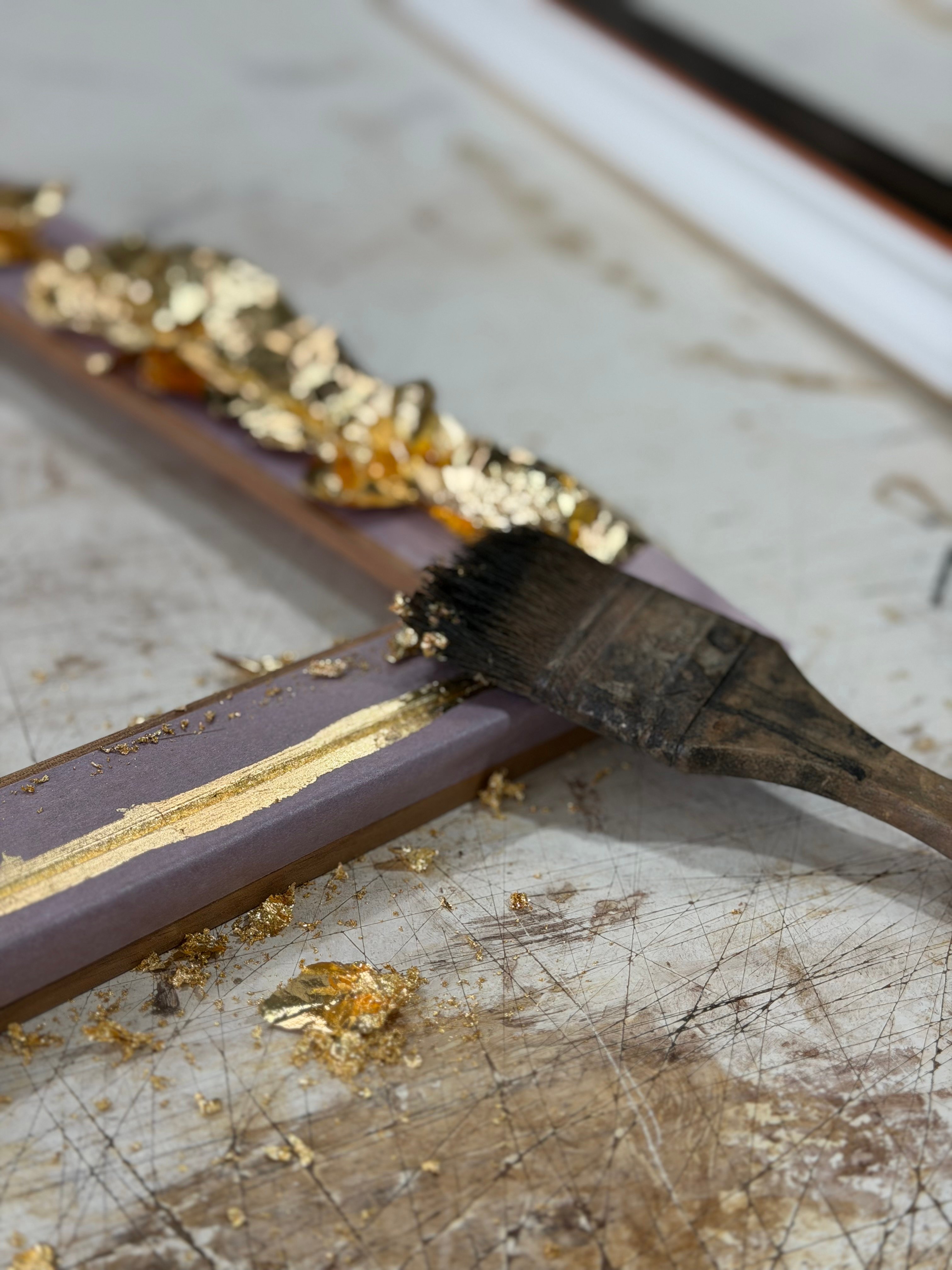 A close up of a hand gilded frame with brush mid process at Dawsons Framing Gold Coast