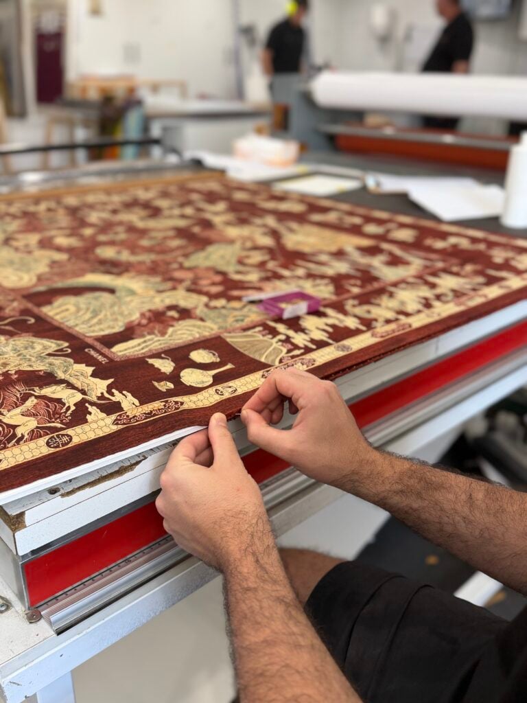 hand pinning a vintage Chanel silk scarf prior to framing at Dawsons Framing Ashmore