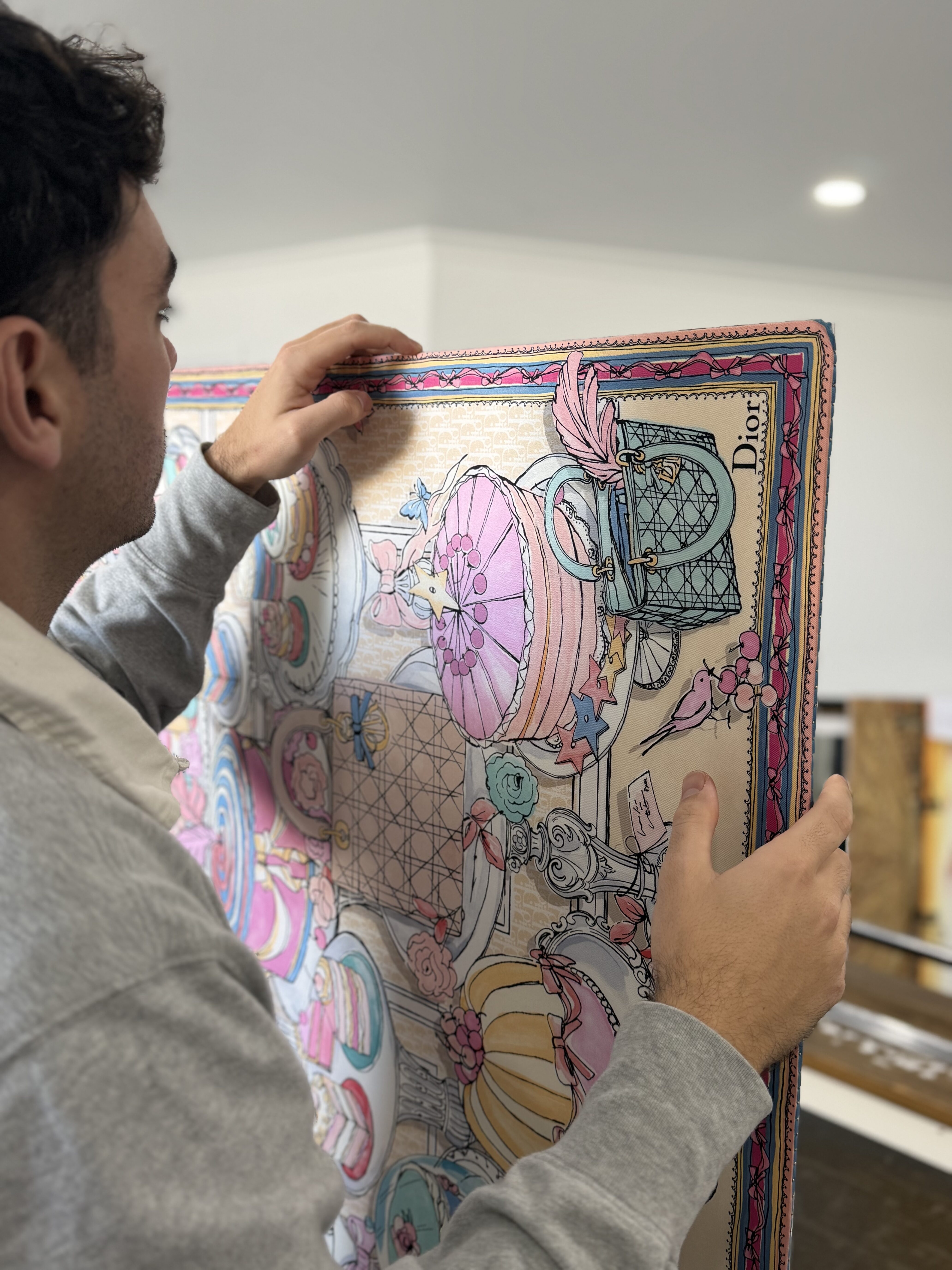 Hand pinning a Dior silk scarf prior to framing at Dawsons Framing Gold Coast