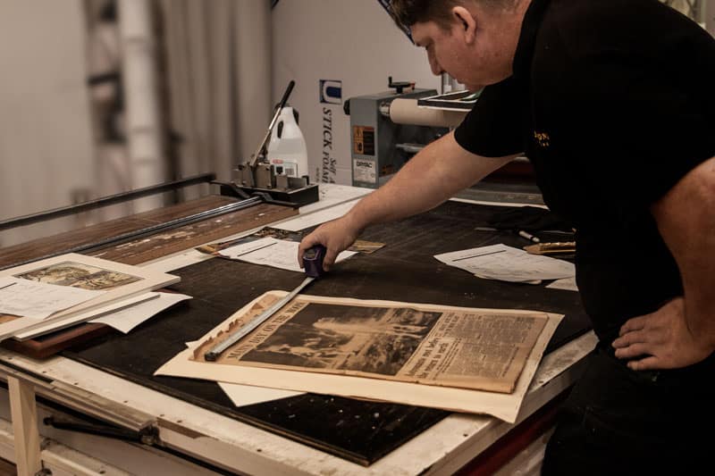 Why is picture framing so expensive? Our team is qualified and experience in unique framing and preservation techniques. Measuring up a 1960's newspaper print for picture framing in Ashmore on the Gold Coast