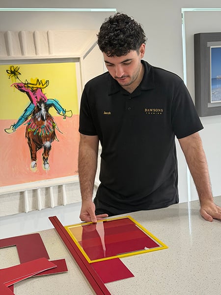 Framer Jacob carefully choosing the correct colour mat board at Dawsons Handcrafted Gold Coast